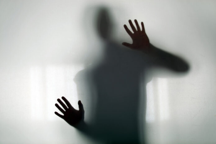 Shadowy figure behind glass