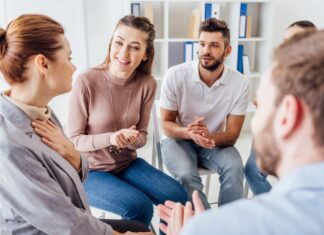 Videreutdanning i Åpen dialog i nettverk og dialogiske praksiser En gruppe mennekser som sitter i sirkel og snakker sammen.